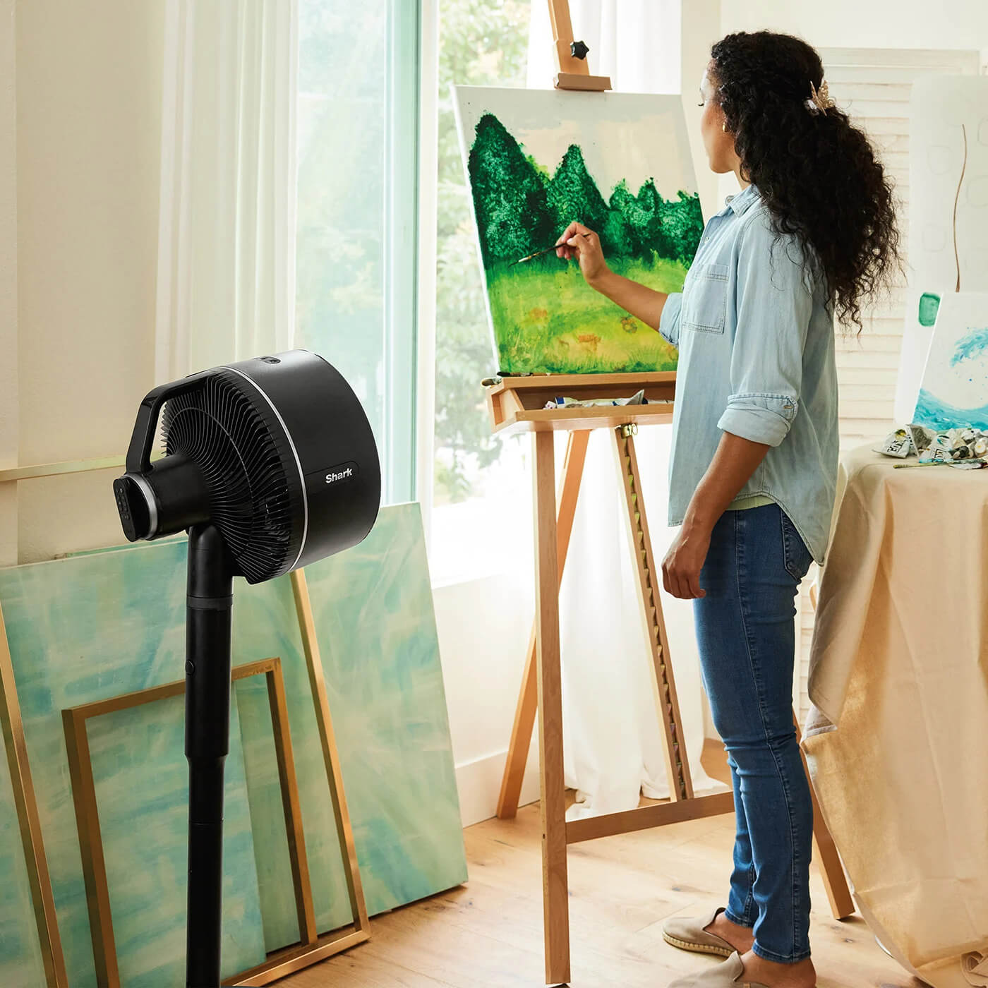 Image of woman painting in a art studio with the Shark FA220UK