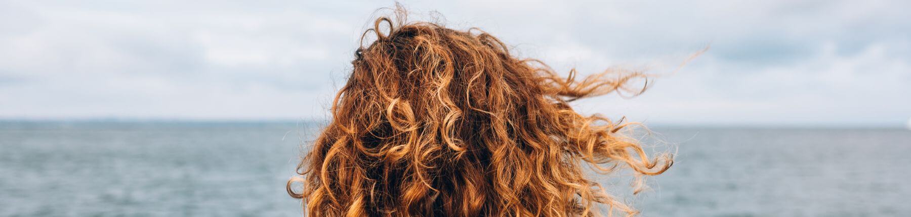 Curly hair on a windy day by the sea
