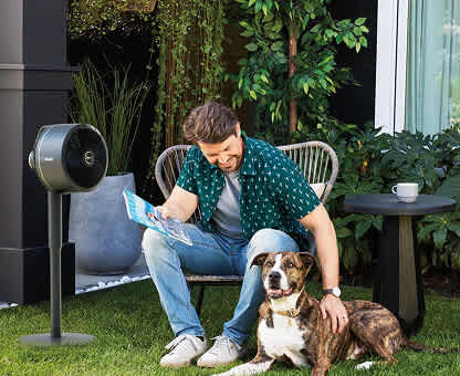 Image of man and dog sat in the garden with the Shark FlexBreeze fan